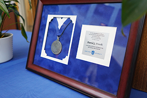 A medal is framed sitting on a table.