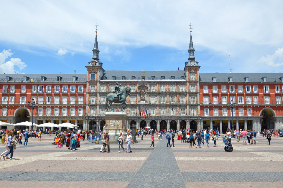 A photo of a crowd walking around Madrid's Plaza Mayor.