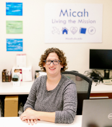 Emily Komos sits at a desk