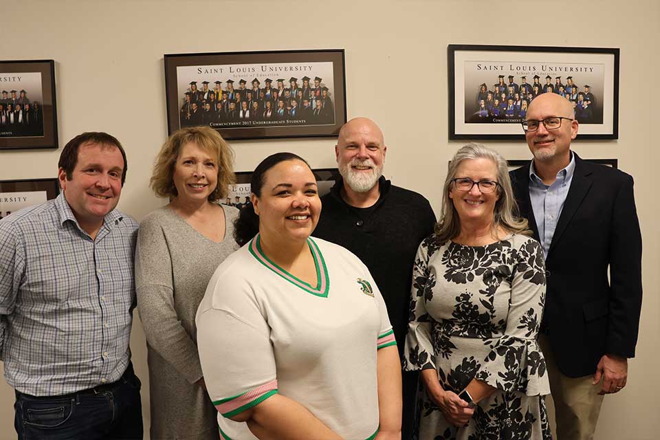 A group of professors gather in the School of Education at Saint Louis University. 