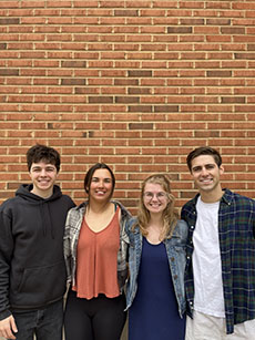 Matthew DiValerio, James Spriggs, Gabbie Kowalik, Mattie Zautner posed in front of a brick wall